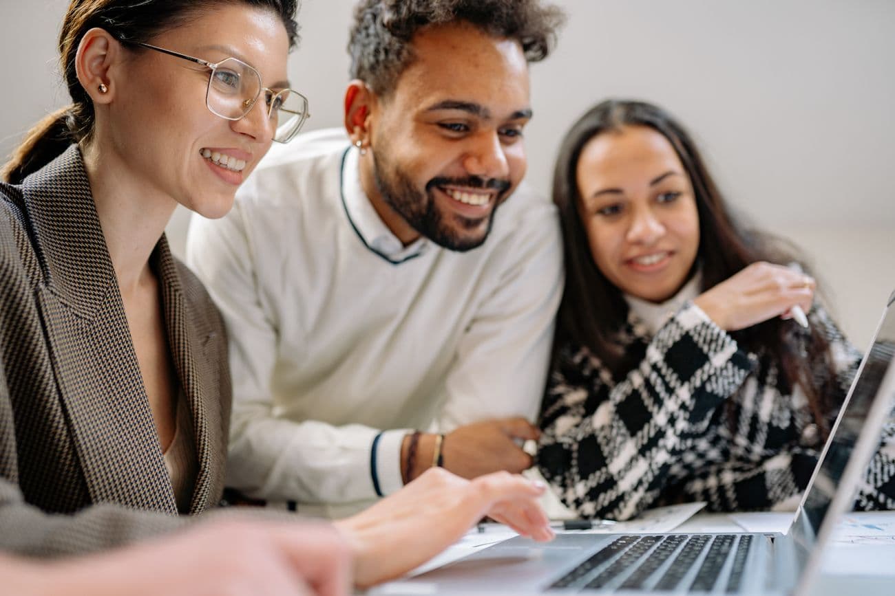 Smiling team reviewing growth results on a laptop