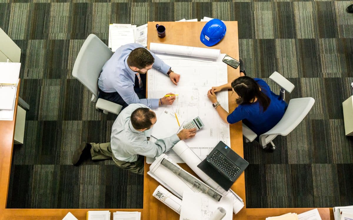 Team reviewing construction blueprints around a table
