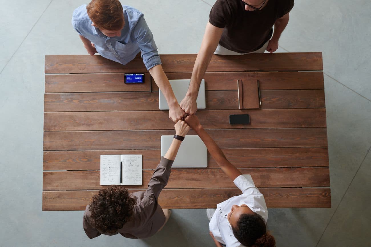 Team fist-bump over a meeting table
