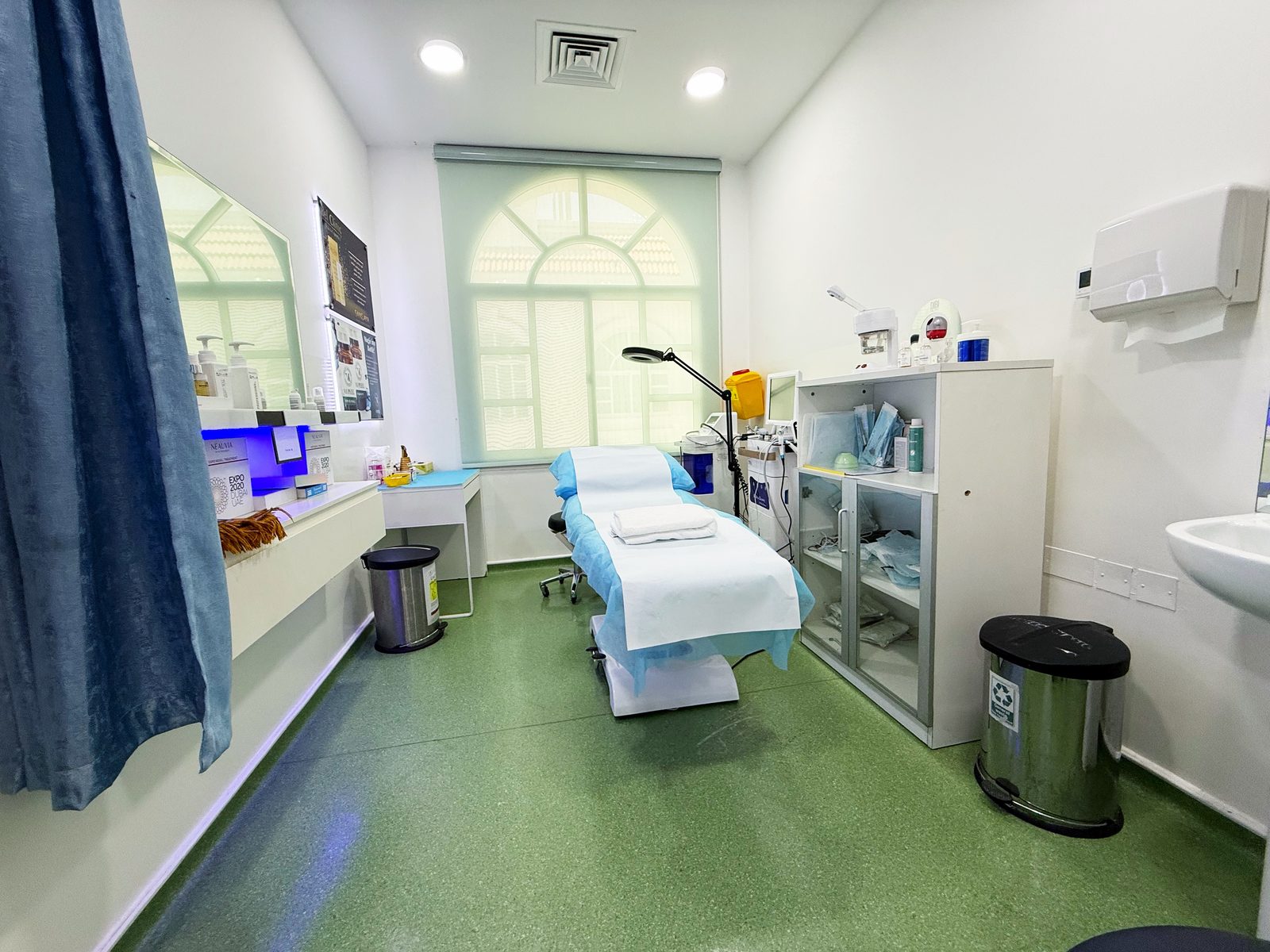 Treatment room with bed and supply cabinet in a poly clinic in Jumeirah, Dubai